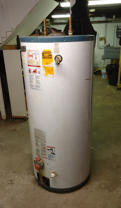 A water heater tank with a technician adjusting the temperature settings